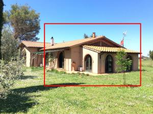 a small house in a field with a red box at Relais Casale Il Poggetto - OLIVO 1 by Zoom In Earth in Cecina