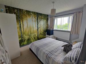 Dan's House في مانشستر: غرفة نوم بسرير مع لوحة اشجار