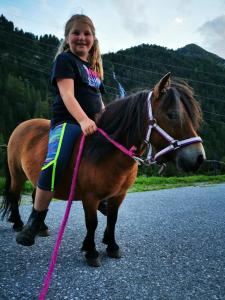 Une jeune fille assise sur un cheval dans l'établissement Wieserhof Tirol, à Oetz