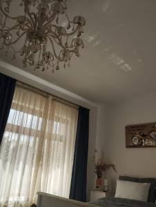a chandelier hanging from a ceiling in a bedroom at casa Flav in Iaşi
