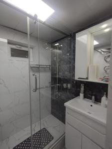 a bathroom with a glass shower and a sink at Small house in a centr in Dushanbe