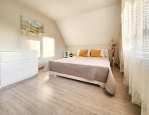 ein Schlafzimmer mit einem Bett und einer Kommode in der Unterkunft Pušynas in Birštonas