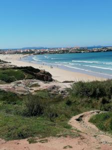 una spiaggia con persone che camminano sulla sabbia e sull'acqua di Baleal Atlantic Villa a Baleal