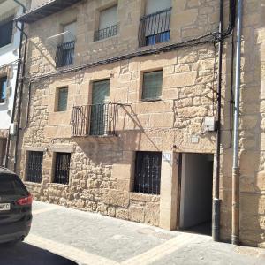 a stone building with a door and a balcony at Casa Dolare a 4 kilometros de Laguardia in Leza
