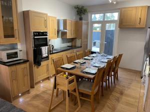 a kitchen with a wooden table with chairs and a dining room at Dog Friendly Town House in Paignton