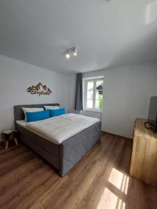 1 dormitorio con 1 cama grande con almohadas azules en AlpenLodge Berchtesgaden, en Berchtesgaden