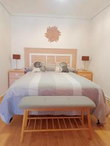 a bedroom with a large bed with two night stands at Casa Dolare a 4 kilometros de Laguardia in Leza