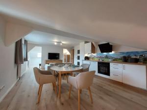 eine Küche und ein Esszimmer mit einem Tisch und Stühlen in der Unterkunft AlpenLodge Berchtesgaden in Berchtesgaden