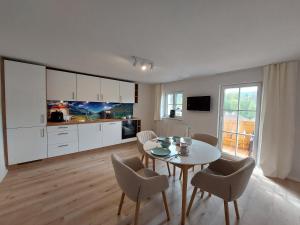 - une cuisine et une salle à manger avec une table et des chaises dans l'établissement AlpenLodge Berchtesgaden, à Berchtesgaden