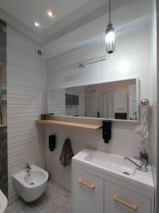 een badkamer met een wastafel, een toilet en een spiegel bij apartament ultracentral Pathfinder in Târgu-Mureş