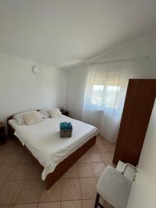 Un dormitorio con una cama grande con una cesta. en Apartments Duda, en Vir