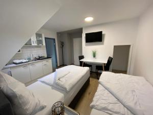 a room with two beds and a kitchen with a table at Apartment Q im Zentrum von Königsbronn Monteurzimmer in Königsbronn