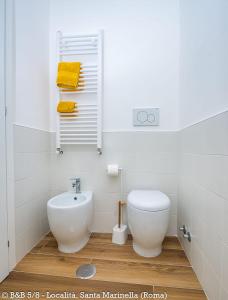 a white bathroom with a toilet and a sink at CINQUE OTTAVI B&B in Santa Marinella +44 photos