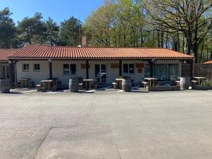 un edificio con mesas de picnic delante de él en Mobile home 3 chambres Camping Cœur de Vendée 3 étoiles, en La Boissière-de-Montaigu