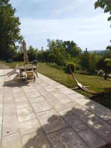 a patio with a table and a chair and a hose at La Coste Blanque in Montaut