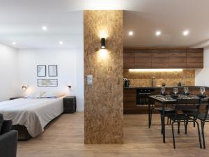 um quarto com uma cama, uma mesa e uma cozinha em L'Escapade Roannaise em Roanne