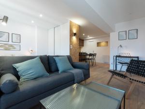 ein Wohnzimmer mit einem blauen Sofa und einem Tisch in der Unterkunft L'Escapade Roannaise in Roanne