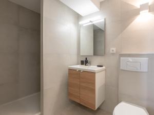 a bathroom with a sink and a toilet and a mirror at L'Escapade Roannaise in Roanne