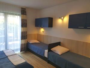 una camera d'albergo con due letti e una finestra di OW Posejdon a Łazy