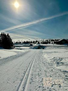 een besneeuwde weg met bandensporen in de sneeuw bij New apartment Hafjelltoppen ski inout in Hafjell