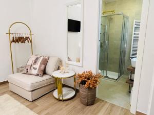 a living room with a couch and a glass shower at Private room Thalia Apartments Mestre in Mestre