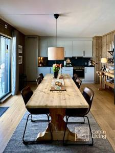 uma cozinha com uma grande mesa de madeira com cadeiras em New apartment Hafjelltoppen ski inout em Hafjell