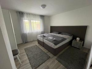 a bedroom with a bed and a window with rugs at Natalie in Münsingen