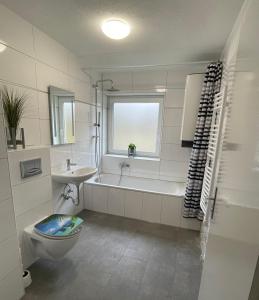 ein Badezimmer mit einer Badewanne, einem WC und einem Waschbecken in der Unterkunft Natalie in Münsingen