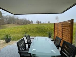 a glass table and chairs on a patio at Natalie in Münsingen