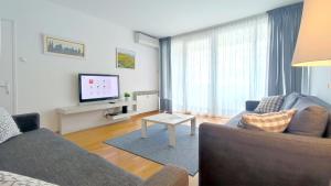 a living room with a couch and a tv at Central point in Zagreb