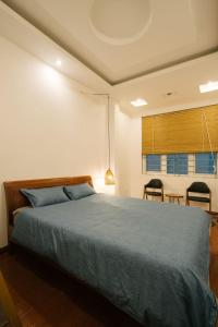 1 dormitorio con 1 cama, mesa y sillas en Michi 6 en Hanoi