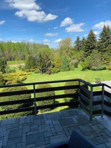 a fence on a patio with a view of a park at Dom Wiktor in Tarnowiec