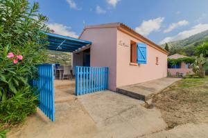 a house with a blue gate in front of it at Résidence Itylon in Cargèse