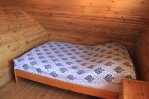 a small bed in a room with wooden walls at NIKA in Stegna