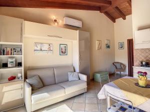 een woonkamer met een bank en een tafel bij Grazioso attico vicino alla spiaggia e al centro in Castelsardo