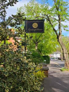 ein Schild für ein Hotel in einer Straße mit Bäumen in der Unterkunft Roseleigh House in Belfast