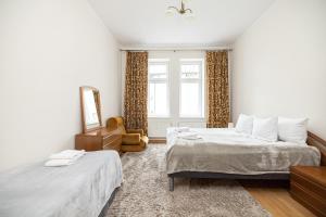a bedroom with two beds and a mirror at Apartamenty Vincent Sopot in Sopot