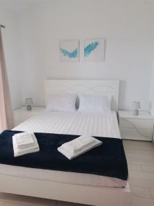 um quarto com uma cama branca com duas toalhas em Oceanus em Faja Grande