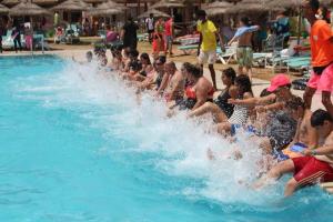 un groupe de personnes jouant dans une piscine dans l'établissement Welcome Meridiana Resort - Families and Couples Only, à Djerba