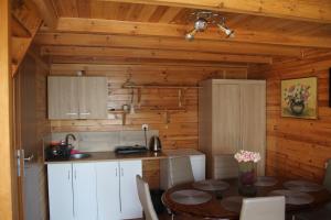 eine Küche und ein Esszimmer mit einem Tisch in einer Hütte in der Unterkunft NIKA in Stegna