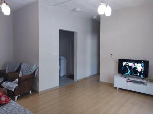 uma sala de estar vazia com uma televisão e um sofá em Io's apartments 