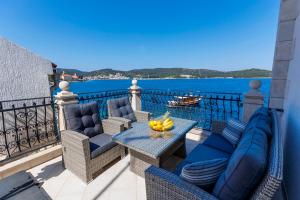 a balcony with chairs and a table with bananas on it at Seafront Apartment For4 in Vis