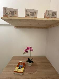 una flor en un jarrón sobre una mesa con un libro en La quiete, en Ceglie Messapica