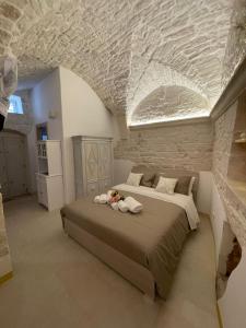a bedroom with a large bed in a stone wall at La quiete in Ceglie Messapica