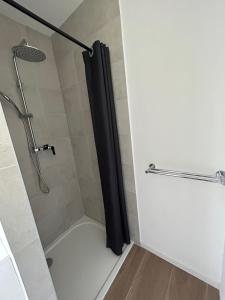 a shower with a black shower curtain in a bathroom at Maison 9 couchages avec piscine et jardin au calme in Barbaggio