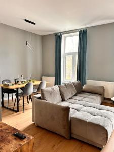 ein Wohnzimmer mit einem Sofa und einem Tisch in der Unterkunft LV Luxury Apart - One minute away from train station in Predeal