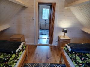 a room with two beds in a wooden cabin at Ranczo Rykowisko in Kołodzieje