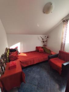 - un salon avec un canapé rouge et 2 tables rouges dans l'établissement Apartmani Nikola, à Bar