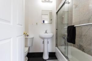 a bathroom with a sink and a toilet and a shower at Studio Plus - Cozy Apartments in New York