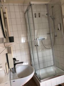 a bathroom with a glass shower and a sink at Alex -Lounge -Sportsbar -Smokerlounge in Otterbach